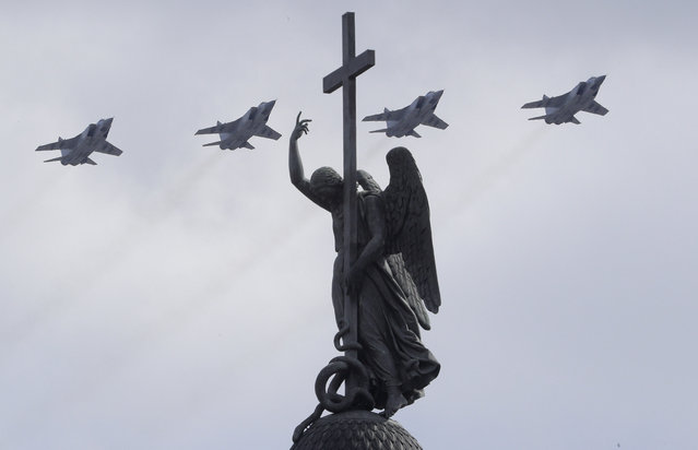 Mikoyan MIG-31, supersonic all-weather long-range jets fly over a statue of an angel fixed atop the Alexander Column during the Victory Day military parade in St. Petersburg, Russia, on Tuesday, May 9, 2017. (Photo by Dmitri Lovetsky/AP Photo)