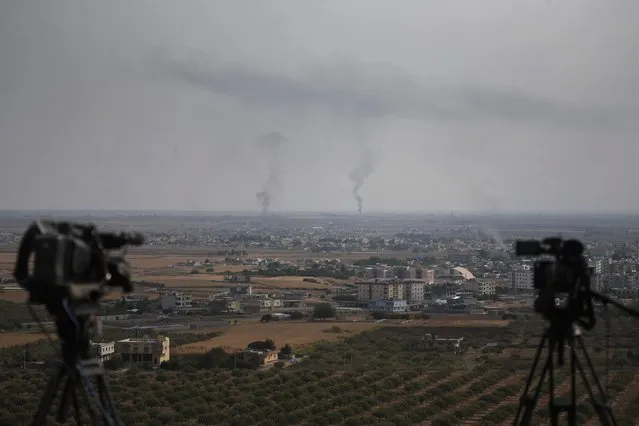 TV cameras are seen on a hilltop in Ceylanpinar, Sanliurfa province, southeastern Turkey, as in the background smoke billows from fires in Ras al-Ayn, Syria, Sunday, October 20, 2019. Turkey's defense ministry says one soldier has been killed amid sporadic clashes with Kurdish fighters in northern Syria, despite a U.S.-brokered cease-fire. The ministry also said it allowed a 39-vehicle humanitarian convoy to enter Ras al-Ayn, a key border town that's seen some of the heaviest fighting. (AP Photo/Lefteris Pitarakis)