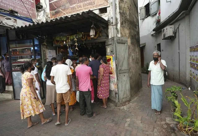 Sri Lankans crowd a grocery store before the beginning of curfew in Colombo, Sri Lanka, Saturday, April 2, 2022. (Photo by Eranga Jayawardena/AP Photo)