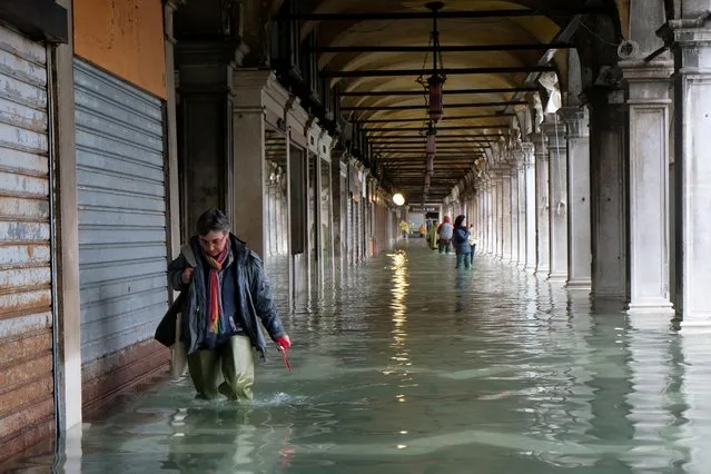 A person walks in the flooded St.Mark's Square during a period of seasonal high water in Venice, Italy on November 12, 2019. (Photo by Manuel Silvestri/Reuters)