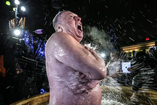 Russian Liberal Democratic Party Leader Vladimir Zhirinovsky dips into a basin of cold water during celebrations of Orthodox Epiphany in Revolution Square. In Eastern Christianity, the feast of Epiphany commemorates the Baptism of Jesus. The Russian Orthodox Church celebrates the holiday according to the Julian calendar. (Photo by Valery Sharifulin/TASS)