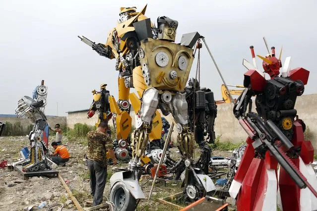 Workers work on “Transformers” replicas on the outskirts of Shanghai, June 18, 2014. Li Lei, owner of a small factory, uses his spare time and money to build “Transformers” replicas for rent or sale. The new Transformers movie, which is premiering later this month, has brought the factory many new orders, according to Li. (Photo by Aly Song/Reuters)