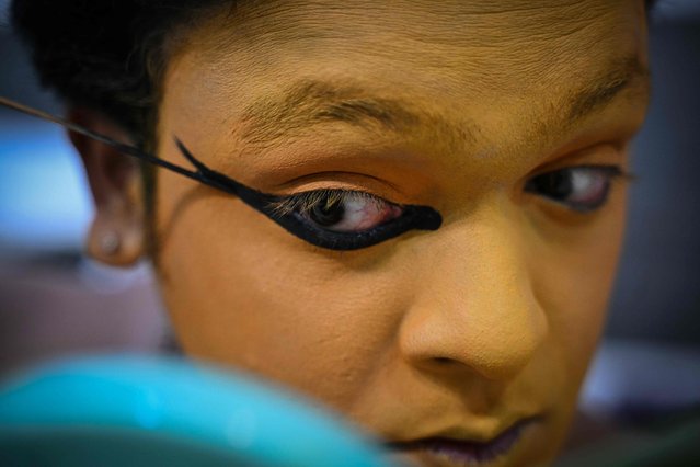 An artist prepares before performing Kathakali, a traditional form of classical Indian dance, during a show at a cultural festival in Chennai on September 12, 2024. (Photo by R.Satish Babu/AFP Photo)