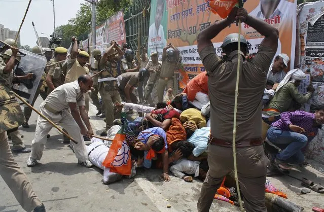 Indian policemen use batons to disperse youth wing workers of India's ruling Bharatiya Janata Party (BJP) during a protest outside the state assembly in the northern Indian city of Lucknow June 30, 2014. Hundreds of workers on Monday protested against the state government over what they say, deteriorating law and order situation in the Uttar Pradesh state, local media reported. (Photo by Pawan Kumar/Reuters)