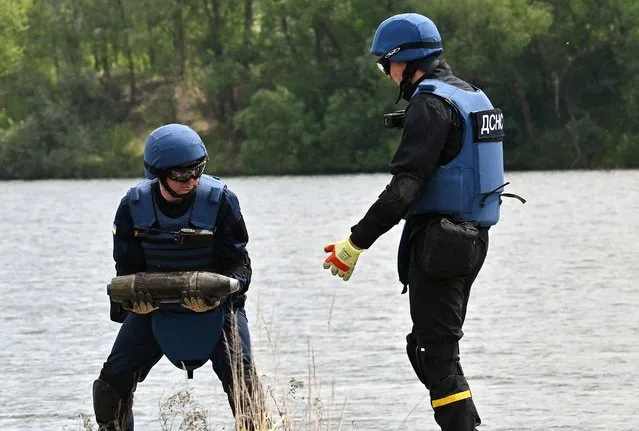 Ukrainian deminers collect unexploded material during demining works on Blue Lake in Horenka village, Kyiv region on May 27, 2022 due to the approaching bathing season. (Photo by Sergei Supinsky/AFP Photo)