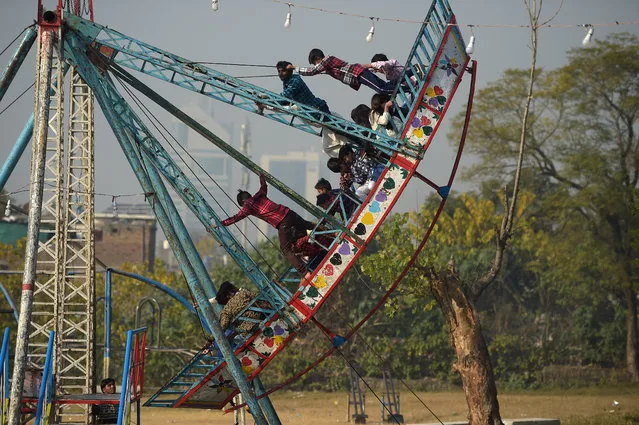 Children ride on a swing on Christmas Day in Islamabad on December 25, 2019. (Photo by Aamir Qureshi/AFP Photo)