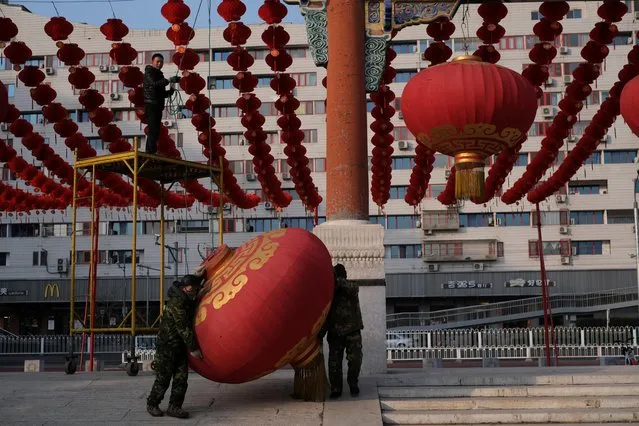 Workers dismantle decorations after the temple fair for the Chinese Lunar New Year in Ditan Park was canceled in Beijing, China on January 24, 2020. (Photo by Carlos Garcia Rawlins/Reuters)