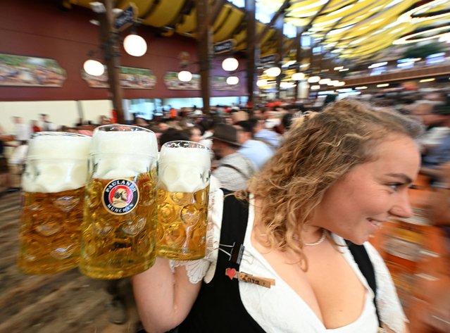 A waitress carries beer mugs on the day of the official opening of the 189th Oktoberfest, the world's largest beer festival in Munich, Germany on September 21, 2024. (Photo by Angelika Warmuth/Reuters)