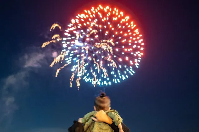 A kid watches fireworks during the Yokohama port festival, which is held completely in the field for the first time in 3 years with no restriction on number of attendees and less strict COVID-19 pandemic restrictions, to mark the 163rd anniversary for the opening of the Port of the city, at at Rinko Park in Yokohama on June 2, 2022. (Photo by Philip Fong/AFP Photo)