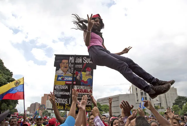 A supporter of Venezuela's President Nicolas Maduro is tossed into the air before the start of a march to the National Assembly for the swearing-in ceremony of the Constitutional Assembly, in Caracas, Venezuela, Friday, August 4, 2017. Venezuelan President Nicolas Maduro is heading toward a showdown with his political foes, preparing to seat a loyalist assembly that will rewrite the country's constitution and hold powers that override all other government branches. (Photo by Wil Riera/AP Photo)