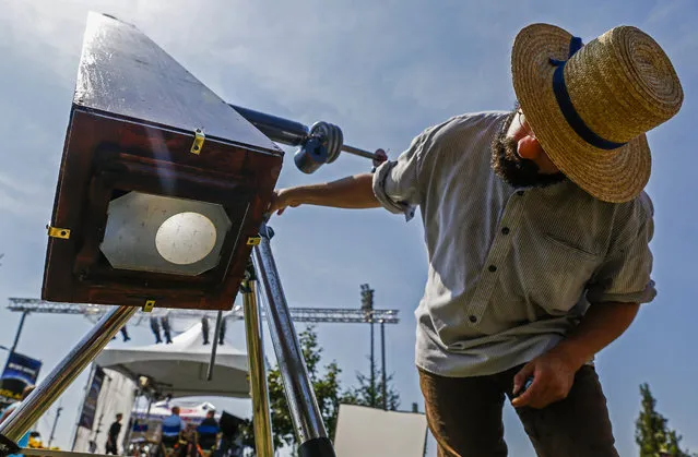 C.D. Olsen adjusts the image on his replica of a kew photoheliograph camera as it displays an image of the sun on the campus of Southern Illinois University before the start of a total solar eclipse in Carbondale, Illinois, USA, 21 August 2017. The 21 August 2017 total solar eclipse will last a maximum of 2 minutes 43 seconds and the thin path of totality will pass through portions of 14 US states, according to the National Aeronautics and Space Administration (NASA). (Photo by Tannen Maury/EPA)