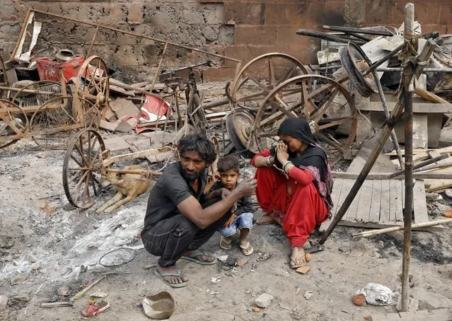 A woman, her husband and their child sit next to their damaged property after their house was burnt by a mob on Tuesday after clashes erupted between people demonstrating for and against a new citizenship law in New Delhi, India, February 28, 2020. At least 38 people were killed in Hindu-Muslim violence this week in the worst bout of sectarian violence in the capital in decades, amid mounting international criticism that authorities failed to protect minority Muslims. (Photo by Adnan Abidi/Reuters)
