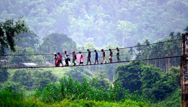 Villagers from Meghalaya state cross a bridge over the Shree river to buy goods from Ukiam weekly market in South Kamrup district of Assam state, India, 11 July 2016. Ukiam is one of the most backward villages of Assam state where every week Khasi people from neighbouring Meghalaya state come to sell and buy goods. (Photo by EPA/Stringer)