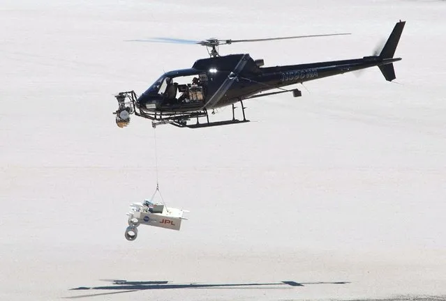 This test for the radar system to be used during the August 2012 descent and landing of NASA Mars rover Curiosity mounted an engineering test model of the radar system onto the nose of a helicopter. During the final stage of descent, NASA's Mars Science Laboratory mission will use a “sky crane” maneuver to lower Curiosity on a bridle from the mission's rocket-powered descent stage. The descent stage will carry Curiosity's flight radar. This test on May 12, 2010, at NASA Dryden Flight Research Center, in Edwards, California, included lowering a rover mockup on a tether from the helicopter to assess how the sky crane maneuver will affect descent-speed determinations by the radar. (Photo by NASA)