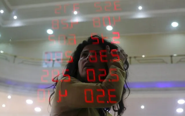 A woman reacts as she reads a board showing the Real-U.S. dollar and several foreign currencies exchange rates in Rio de Janeiro, Brazil, August 26, 2015. While many of Brazil's largest companies have grown savvy about hedging their debt against big currency swings, an increasing number could feel the heat from the real's plunge to a more than 12-year low due to poor planning and rising debt, bankers said. (Photo by Ricardo Moraes/Reuters)