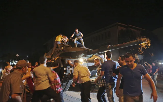 A tank moves into position as Turkish people attempt to stop them, in Ankara, Turkey, late Friday, July 15, 2016. Members of Turkey's armed forces said they had taken control of the country, but Turkish officials said the coup attempt had been repelled early Saturday morning in a night of violence, according to state-run media. (Photo by Burhan Ozbilici/AP Photo)
