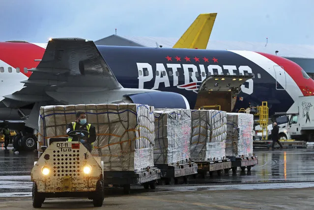 Palettes of N95 respirator masks are off-loaded from the New England Patriots football team's customized Boeing 767 jet on the tarmac, Thursday, April 2, 2020, at Boston Logan International Airport in Boston, after returning from China. The Kraft family deployed the Patriots' team plane to China to fetch more than 1 million masks for use by front-line health care workers to prevent the spread of the new coronavirus. (Photo by Jim Davis/The Boston Globe via AP Photo/Pool)