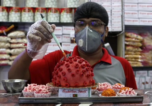 A confectioner applies finishing touches to a replica of coronavirus made out of sweets at a confectionary workshop during a 21-day nationwide lockdown to slow the spreading of coronavirus disease (COVID-19) in Kolkata, India, April 6, 2020. (Photo by Rupak De Chowdhuri/Reuters)