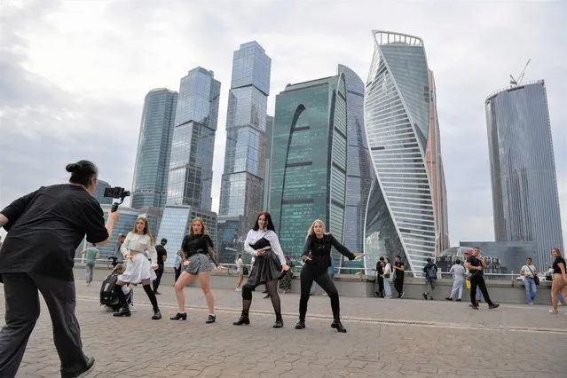 A group of teenagers practice to dance a K-pop, a modern Korean dance during the warm weather at the Moscow's city skyscrapers in Moscow, Russia, Sunday, August 21, 2022. (Photo by AP Photo/Stringer)