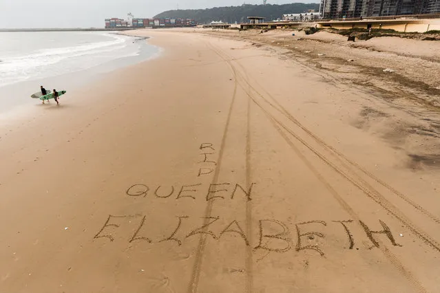 A picture taken on September 9, 2022 in Durban shows message written on sand on the South Beach on the passing of Queen Elisabeth II. Queen Elizabeth II, the longest-serving monarch in British history and an icon instantly recognisable to billions of people around the world, died at her Scottish Highland retreat on September 8 at the age of 96. (Photo by Rajesh Jantilal/AFP Photo)