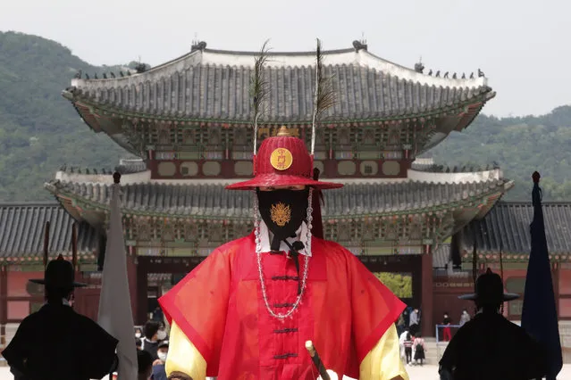 A South Korean Imperial guard waring a face mask stands during a reenactment of the Royal Guards Changing Ceremony, which had been suspended due to the new coronavirus, at Gyeongbok Palace in Seoul, South Korea, Thursday, May 21, 2020. (Photo by Ahn Young-joon/AP Photo)