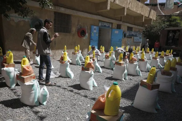 Volunteers prepare free food rations provided by the Mona relief agency to conflict-affected people on World Food Day, in Sana'a, Yemen, 16 October 2022. World Food Day is marked annually on 16 October to promote awareness and action in support of the millions of people worldwide who suffer from hunger. Conflict-ravaged Yemen is experiencing one of the worst humanitarian crisis in the world with over 17.4 million people out of its 30 million population are food insecure and in need of assistance to ward off the risk of famine, according to recent estimates by UN aid agencies. This number is projected to go up to 19 million by December 2022. (Photo by Yahya Arhab/EPA/EFE)