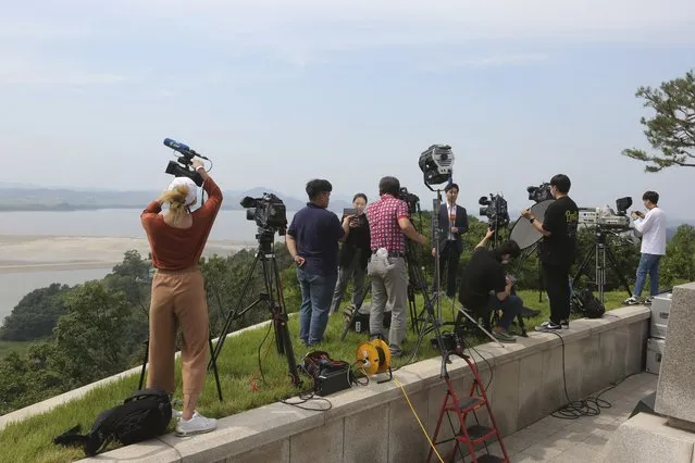 Journalists take video footage from the unification observation post in Paju, South Korea, near the border with North Korea, Wednesday, June 17, 2020. North Korea said Wednesday it will redeploy troops to now-shuttered inter-Korean cooperation sites, reinstall guard posts and resume military exercises at front-line areas, nullifying the tension-reducing deals reached with South Korea just two years ago. (Photo by Ahn Young-joon/AP Photo)