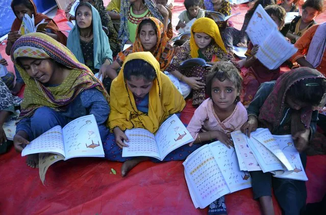 Victims of heavy flooding from monsoon rains attend school at a flood relief camp in Hyderabad, Pakistan, Saturday, September 10, 2022. Months of heavy monsoon rains and flooding have killed over a 1000 people and affected 3.3 million in this South Asian nation while half a million people have become homeless. (Photo by Pervez Masih/AP Photo)