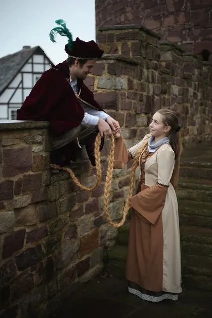 Rapunzel, actually 13-year-old actress Anna Helver, greets her prince, played by actor Daniel Stuebe, on a rampart of Trendelburg Castle on November 18, 2012 in Trendelburg, Germany. Rapunzel is one of the many stories featured in the collection of fairy tales collected by the Grimm brothers, and the 200th anniversary of the first publication of the stories will take place this coming December 20th. Anna and another actor perform a skit based on the Rapunzel tale to visitors at Trendelburg Castle, which is now a hotel, every Sunday. The Grimm brothers collected their stories from oral traditions in the region between Frankfurt and Bremen in the early 19th century, and the works include such global classics as Sleeping Beauty, Little Red Riding Hood, The Pied Piper of Hamelin, Cinderella and Hansel and Gretel.  (Photo by Sean Gallup)