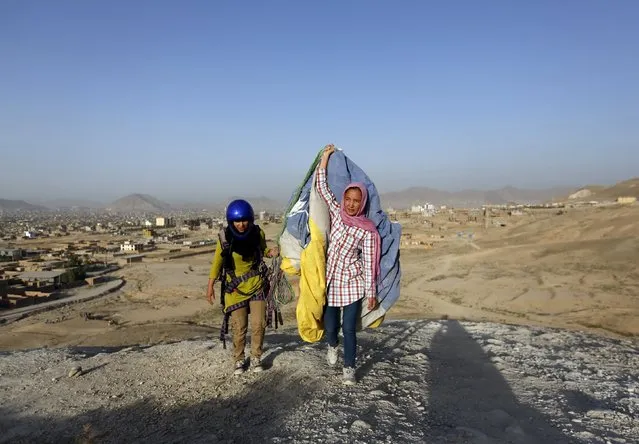 Zakia Mohammadi, 21, (R) walks with Leeda Ozori, 21, after paragliding exercise in Kabul, Afghanistan September 14, 2015. Mohammadi and Ozori are two women in a group of young Afghans taking to the skies of a capital where military helicopters and surveillance balloons are a far more familiar sight. (Photo by Mohammad Ismail/Reuters)