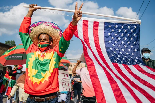 A man carries the U.S. flag as members of the Oromo community march in protest after the death of musician and revolutionary Hachalu Hundessa on July 8, 2020 in St. Paul, Minnesota. The protesters called for Internet service to be restored in Ethiopia that was shut down on June 30. Community leaders also urged the U.S. to aid in the release of Oromian and American prisoners. This latest protest follows the death of Hundessa, who was murdered in Ethiopia on June 29. His death has sparked ongoing protests around the world. (Photo by Brandon Bell/Getty Images)