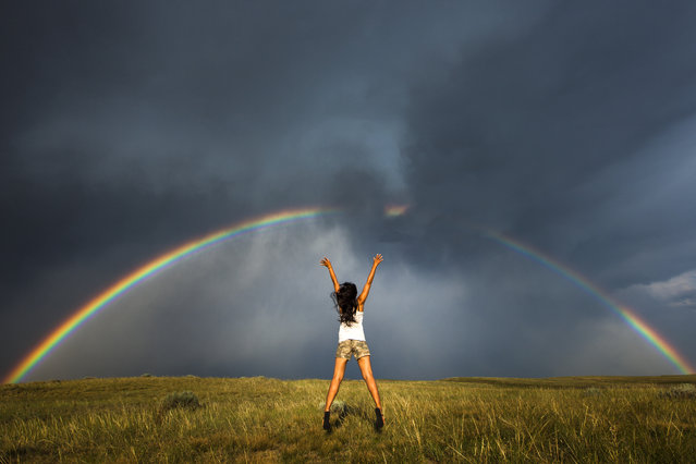 Jump Bow – Daow jumping infront of the rainbow and stormy sky. (Photo by Nicolaus Wegner/Caters News)