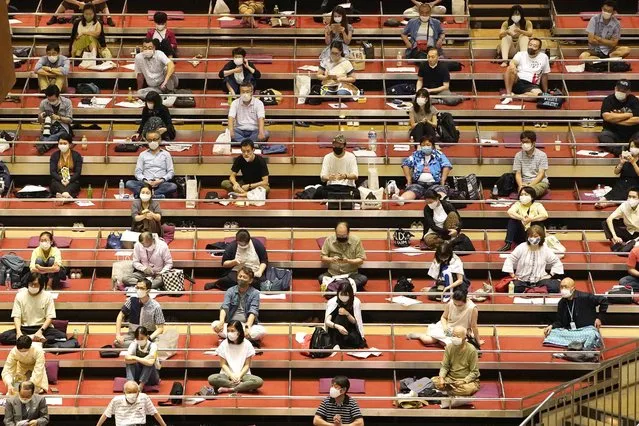 Sumo spectators wearing face mask practice social distance in their seats during the outbreak of the new coronavirus as they watch the first day of the sumo tournament in Tokyo, Sunday, July 19, 2020. (Photo by Kyodo News via AP Photo)