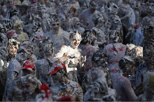 Students from St Andrew's University indulge in a tradition of covering themselves with foam to honour the “academic family” on October 20, 2014, in St Andrews, Scotland. Every November the “raisin weekend” which is held in the university's Lower College Lawn, is celebrated and a gift of raisins (now foam) is traditionally given by first year students to their elders as a thank you for their guidance and in exchange they receive a receipt in Latin. (Photo by Jeff J. Mitchell/Getty Images)