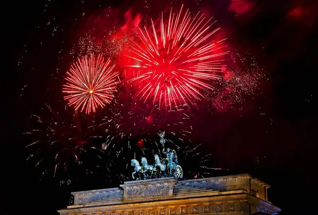 Fireworks explode in the sky above the  Quadriga on the Brandenburg Gate during the New Year's celebrations in Berlin, Tuesday, Jan. 1, 2013. (Photo by Markus Schreiber/AP Photo)