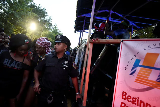 A New York City police officer guards a float participating in the overnight-into-dawn celebration called J'Ouvert, ahead of the annual West Indian-American Carnival Day Parade in Brooklyn, NY, U.S. September 5, 2016. (Photo by Mark Kauzlarich/Reuters)