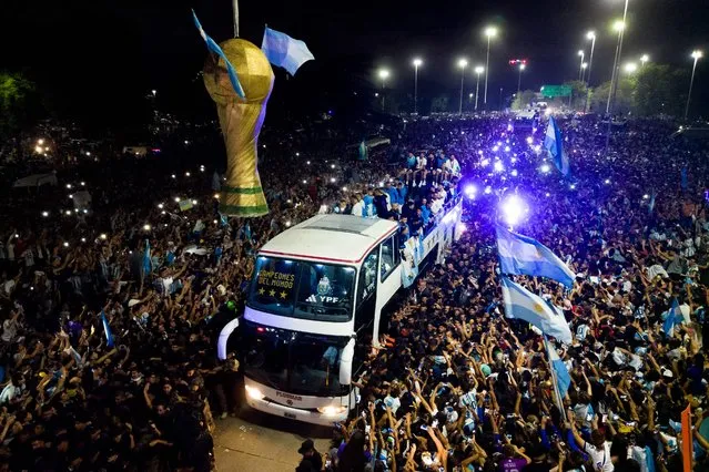 This aerial image taken on December 20, 2022 shows Argentina's players celebrating on board a bus with supporters after winning the Qatar 2022 World Cup tournament as they leave Ezeiza International Airport en route to the Argentine Football Association (AFA) training centre in Ezeiza, Buenos Aires province, Argentina. (Photo by Tomas Cuesta/AFP Photo)