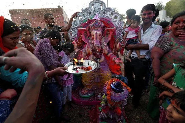 Devotees offer prayers to an idol of the Hindu god Ganesh, the deity of prosperity, as they make their way to the Yamuna river to immerse the idol on the last day of the ten-day-long Ganesh Chaturthi festival in Delhi, India, September 15, 2016. (Photo by Cathal McNaughton/Reuters)