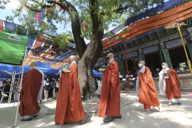 Buddhist monks wearing face masks to help protect against the spread of the coronavirus leave after a service at the Chogyesa temple in Seoul, South Korea, Wednesday, August 26, 2020. Health officials in South Korea called on thousands of striking doctors to return to work as the country counted its 13th straight day of triple-digit daily jumps in coronavirus cases. (Photo by Ahn Young-joon/AP Photo)