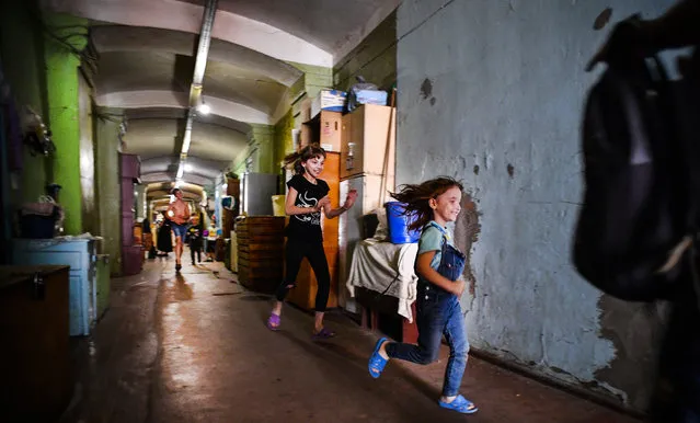 Children play in a communal corridor in a dormitory for the workers of Proletarka textile factory in the town of Tver, 200 kilometres north-west from Moscow on August 8, 2020. (Photo by Andrey Borodulin/AFP Photo)
