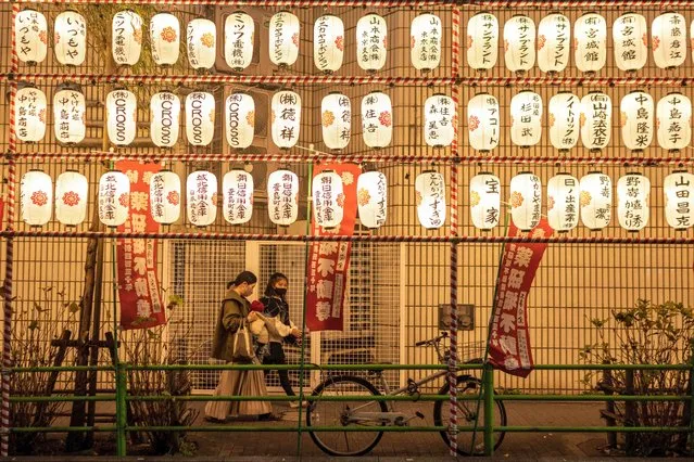 People walk past paper lanterns at a year-end fair in the Nihonbashi district of Tokyo on December 26, 2022. (Photo by Yuichi Yamazaki/AFP Photo)