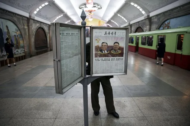 A man reads newspapers displayed inside a subway station in central Pyongyang October 11, 2015. (Photo by Damir Sagolj/Reuters)