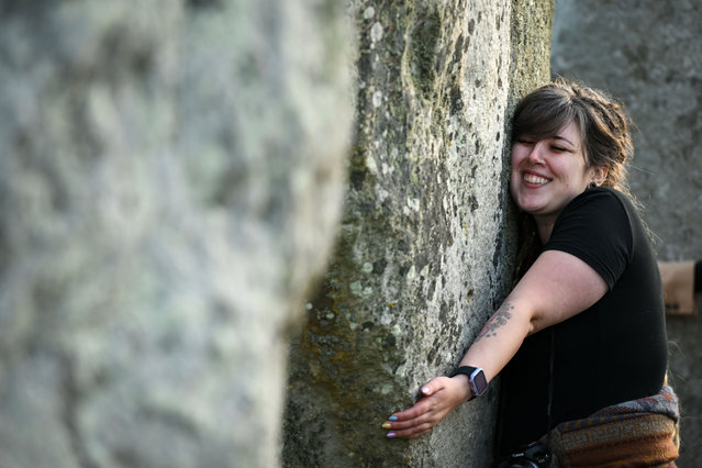 People touch the stones at Stonehenge on June 21, 2023 in Wiltshire, England. In the Northern Hemisphere, the longest day of the year falls on the 21st of June. This day is often referred to as the Summer Solstice or Midsummer's Day. (Photo by Finnbarr Webster/Getty Images)