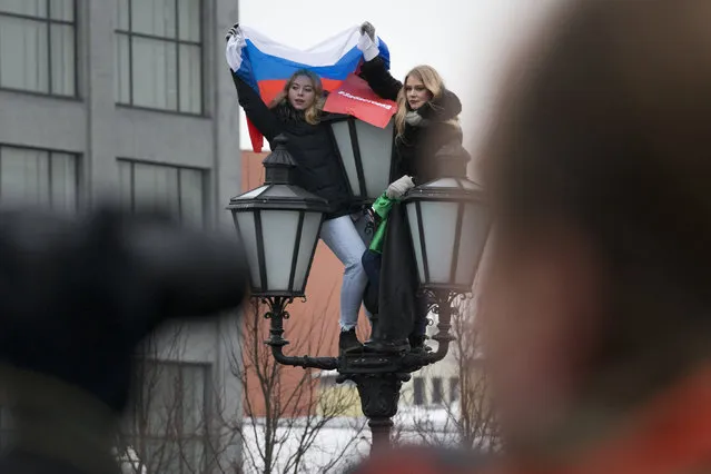 Young protesters hold a Russian national flag during a rally at Pushkin square in Moscow, Sunday, January 28, 2018. (Photo by Alexander Zemlianichenko/AP Photo)