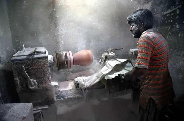 A Pakistani laborer works at a factory that produces handicrafts made up of Salt stones  in Karachi, Pakistan, 13 December 2022. Pakistan hosts Khewra Salt mines, the world's second and Pakistan's largest and oldest salt mine and a major tourist attaction, drawing up to 250,000 visitors a year and dates back to 320 BCE. (Photo by Rehan Khan/EPA/EFE)
