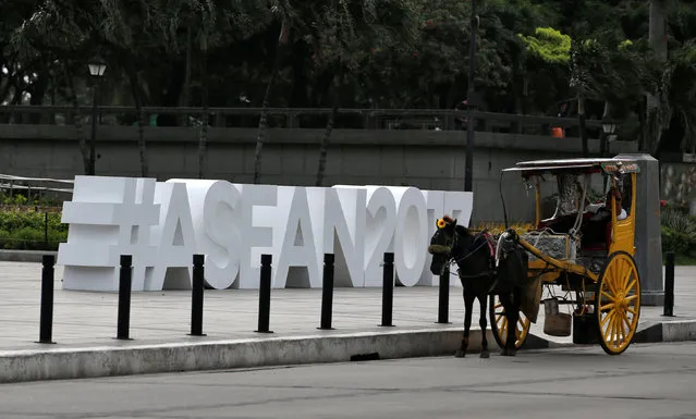 A horse cart driver waits for tourists near the ASEAN logo ahead of the 50th ASEAN Foreign Ministers meeting and in Manila, Philippines August 2, 2017. (Photo by Erik De Castro/Reuters)