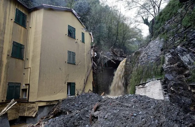 Water flows next to a house hit by a landslide after heavy rains have been battering northern Italy for the last few days, in Voltri, near Genoa, Italy, Monday, November 17, 2014. (Photo by Antonio Calanni/AP Photo)