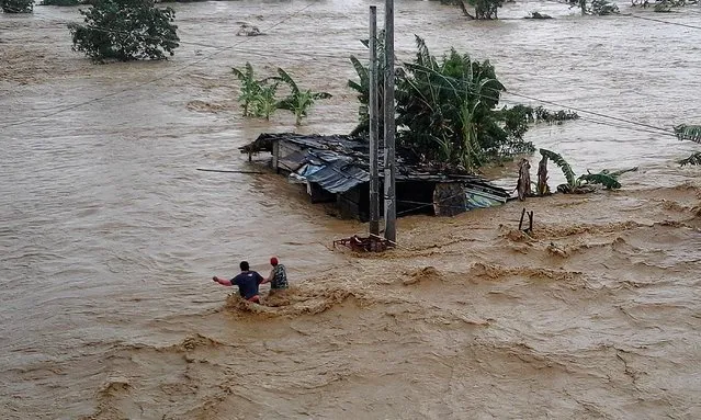 Residents wade through floodwater in Nueva Ecija province, the Philippines on October 19, 2015. Two people died and five other got injured as typhoon Koppu, locally named Lando, continued to batter the northern Philippines, the National Disaster Risk Reduction and Management Council (NDRRMC) reported on Monday.  (Photo by Xinhua via ZUMA Wire)