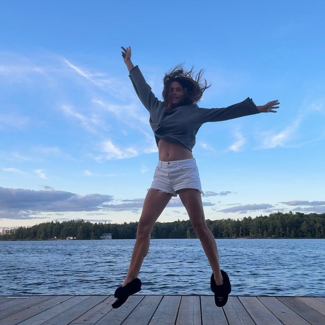 American model Cindy Crawford jumps for joy on a dock in the last decade of July 2025. (Photo by cindycrawford/Instagram)