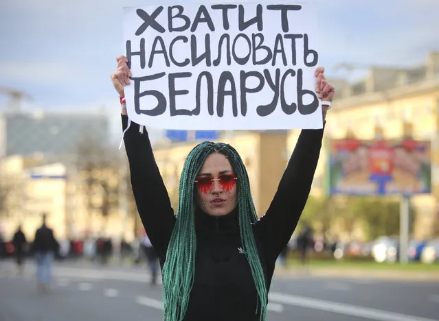 A protester holds a sign reading “Stop raping Belarus” during an opposition rally to protest the official presidential election results in Minsk, Belarus, Sunday, October 18, 2020. (Photo by AP Photo/Stringer)